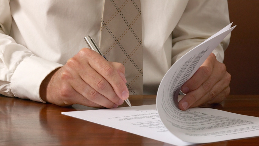 close up of hand signing a contract