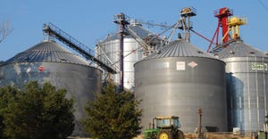 grain bins with tractor in front.