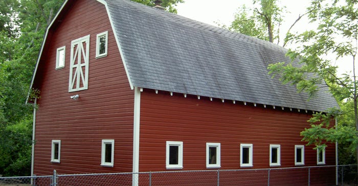 a freshly painted and repaired  red barn