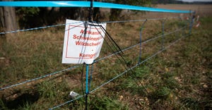 Note that reads "African swine fever in wild boars - core area" stands next to an electric fence to prevent wild boars from l