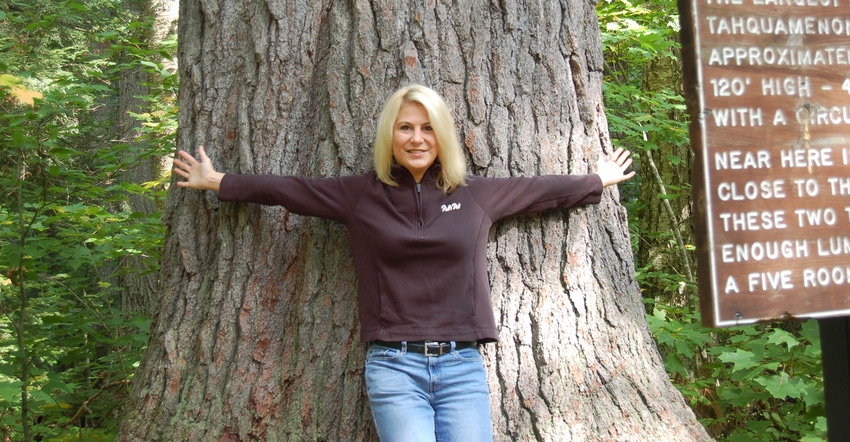 Jennifer Kiel standing in front of massive white pine tree