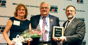 John Scott, with wife Debra, received the Distinguished Service to Agriculture Award from Rick Ebert, Farm Bureau President