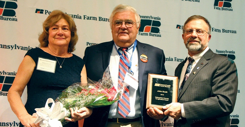 John Scott, with wife Debra, received the Distinguished Service to Agriculture Award from Rick Ebert, Farm Bureau President