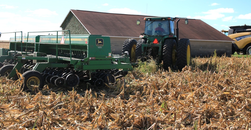 John Deere tractor pulls Deere 750 seed drill in no-till cornfield 