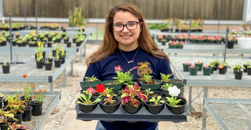 Jaidyn Wommack, Louisiana FFA member,  stands with a tray full of plants