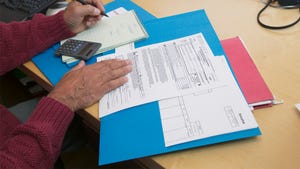 Person at table with hands on folder of financial materials