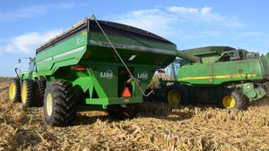 John Deere combine, grain cart and tractor sitting in harvested cornfield