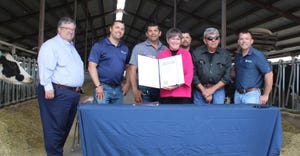 Kansas Gov. Laura Kelly displays the official proclamation she signed declaring June as Kansas Dairy Month at the McCarty Fam