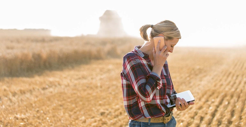Farmer standing in the field on the phone during harvest