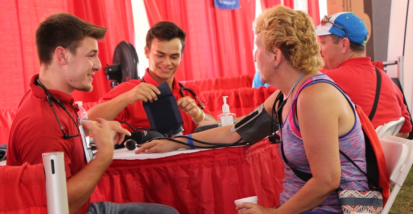 Nursing students  take the blood pressure of a visitor