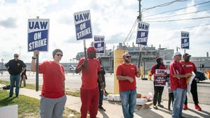 Group of people in red shirts holding UAW strike signs