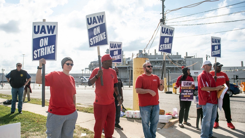 Group of people in red shirts holding UAW strike signs
