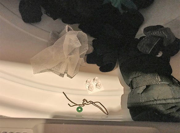wire and white plastic ear tag holder in dryer