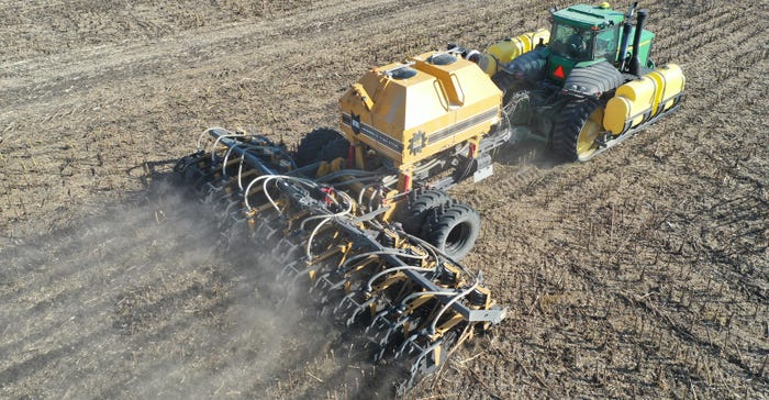 farmer using a soil warrior to lay strips with fertilizer into a harvested sunflower field