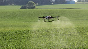 Hylio drone spraying a cornfield