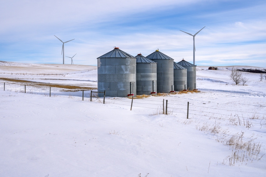 grain storage bins in field of snow
