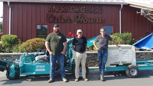 Joe Gaynor, Jeff Crist and Gregory Peck stand with one of the mechanical harvesters tested at Angry Orchard’s experimental orchards in Walden, N.Y.
