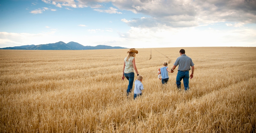 Family walking through cut wheat field