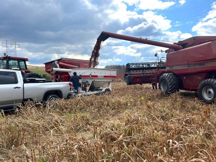 Farmers using tractors and other equipment to harvest a plot