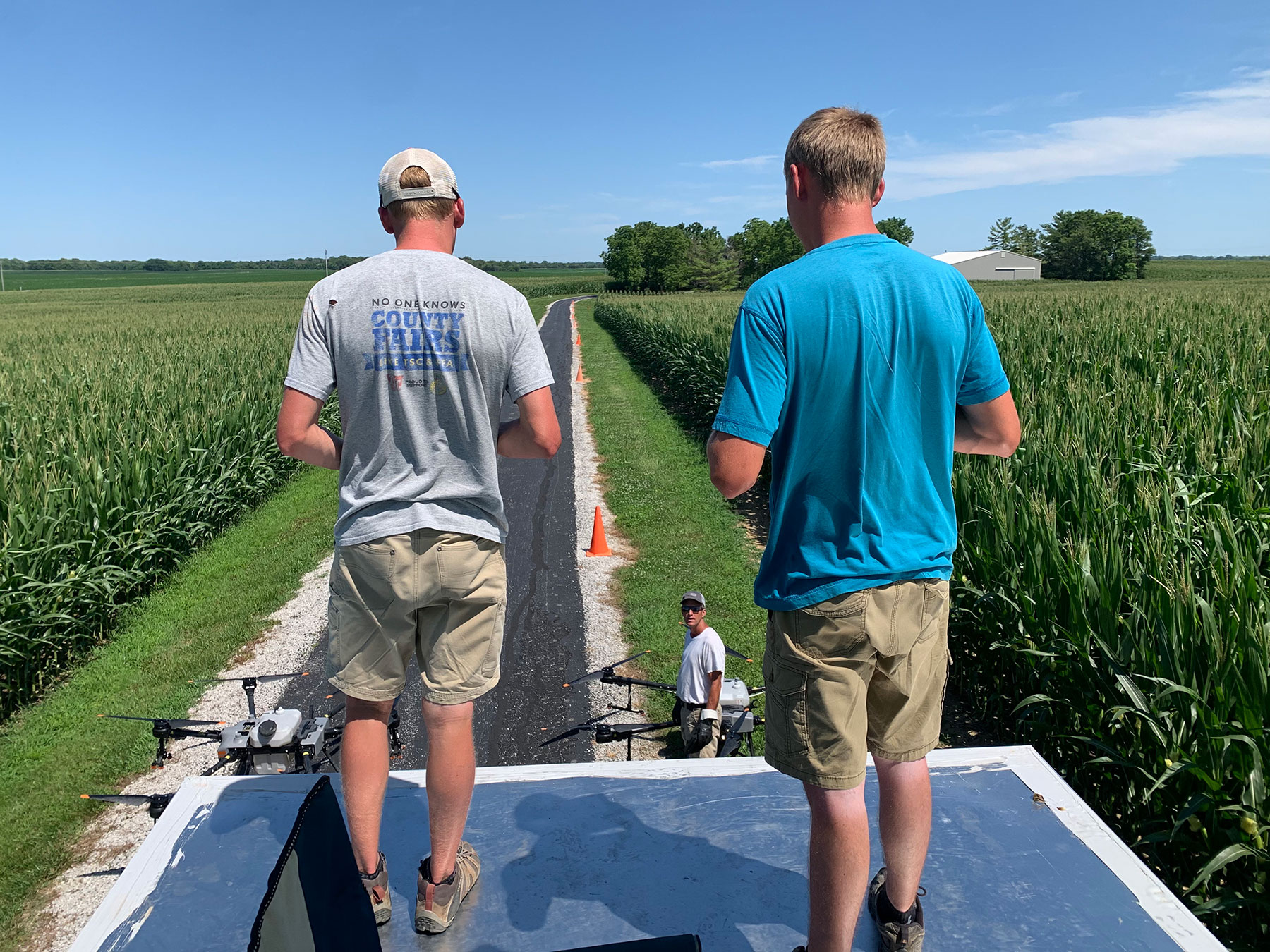 Noah and Jonathan Poynter perched on a tall structure preparing to send drones into flight