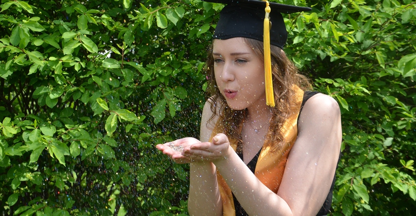 Kayla Bechman in graduation cap blowing glitter off her hand