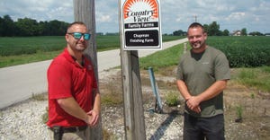 Matthew (left) and Jacob Chapman stand in front of sign