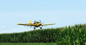 Airplane applying fungicide to field