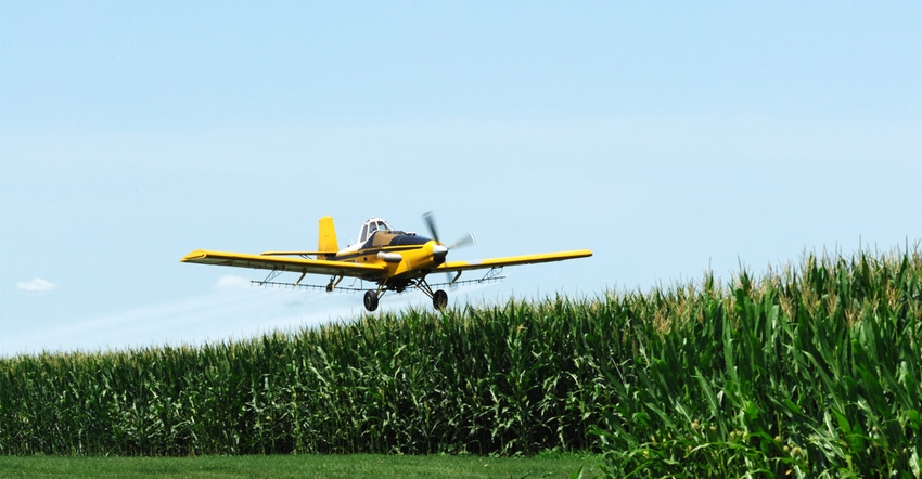 Airplane applying fungicide to field