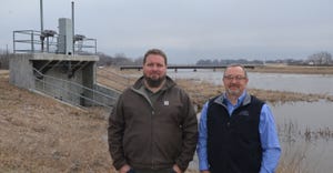 : Jesse Mintken (left) and Lyndon Vogt stand in front of the diversion gate on the Wood River near the Stuhr Museum in Grand 