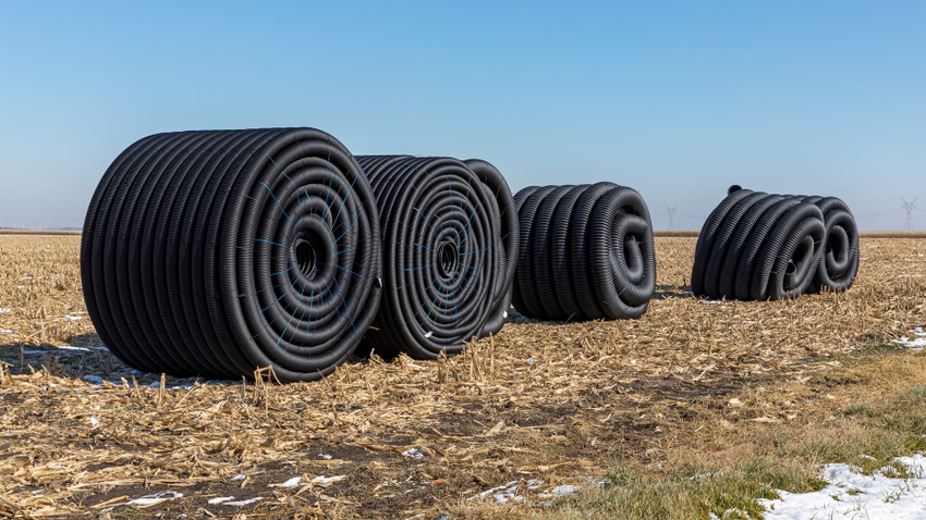 Rolls of drainage tube in harvested cornfield