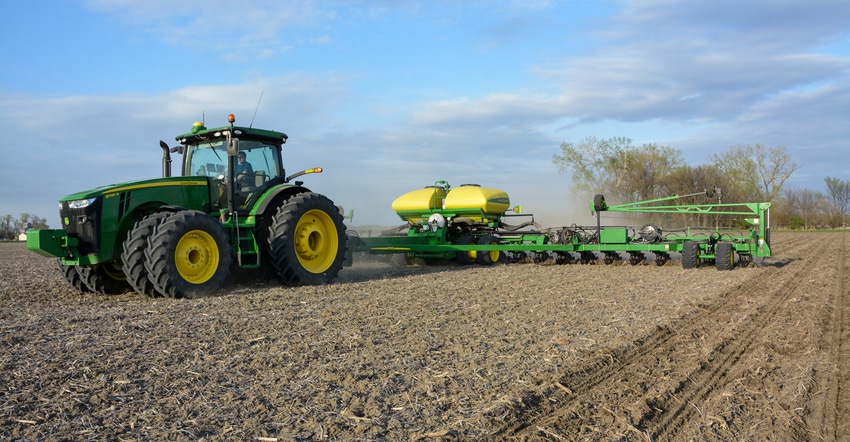 Tractor planting corn in field