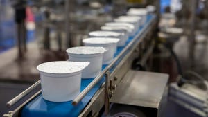 White yogurt packages on a production line in a dairy farm