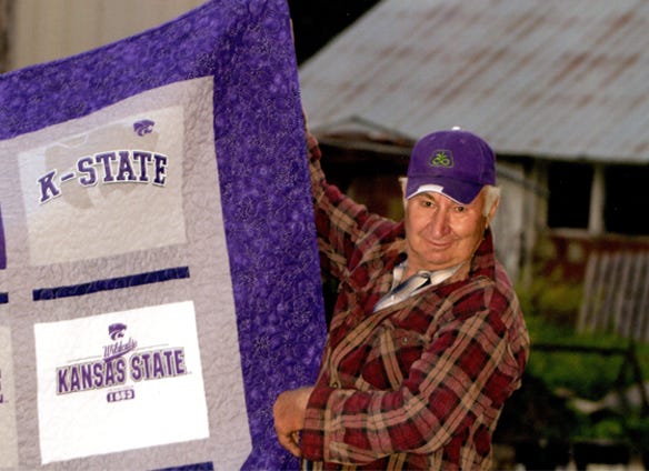 Gary holding a kansas state quilt Delores made