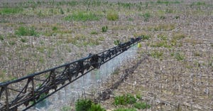 crop sprayer boom spraying herbicide on no-till field