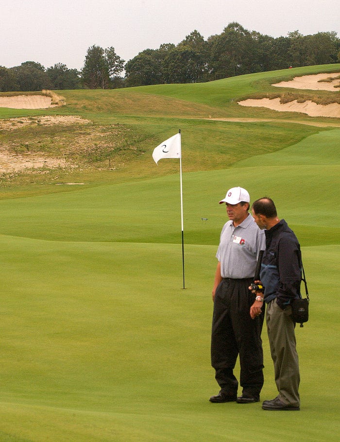 OSU professor Karl Danneberger and fellow faculty member Joe Rimelspach standing on the putting green on a golf course 