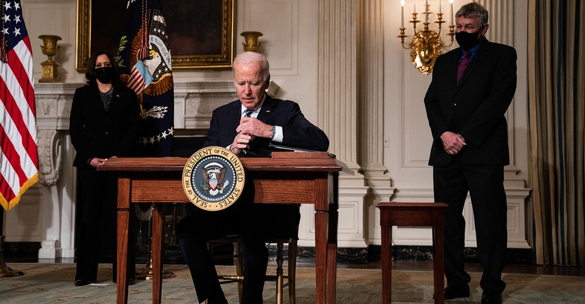 U.S. President Joe Biden signs executive orders after speaking about climate change issues in the State Dining Room of the Wh