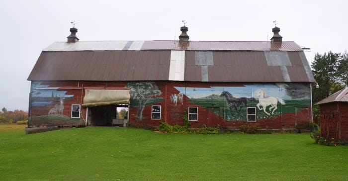 a barn with murals with paintings of  horses, deer and cattle done by Harry Nelson