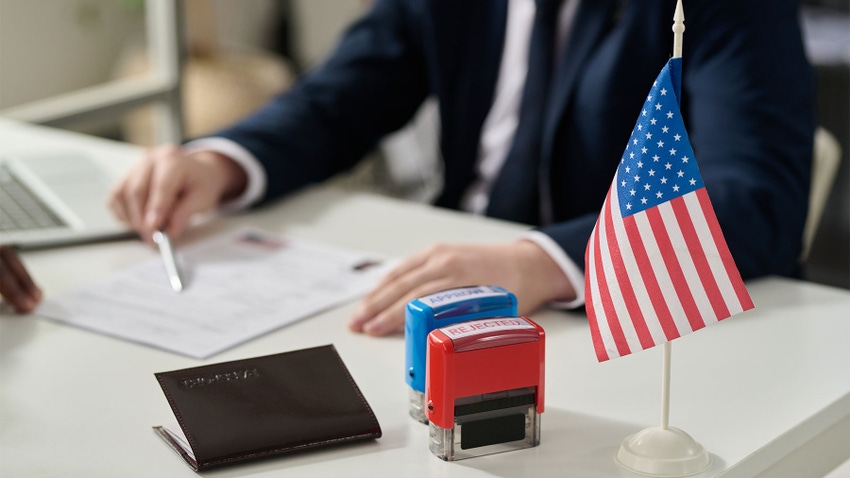 Close up of approved and rejected stamps and an American flag on a table