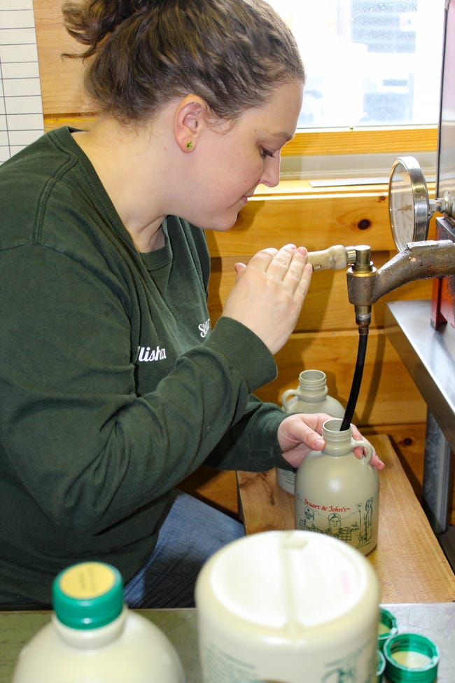 Alisha Adams, helps with bottling maple syrup