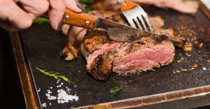 knife and fork cutting into grilled beef