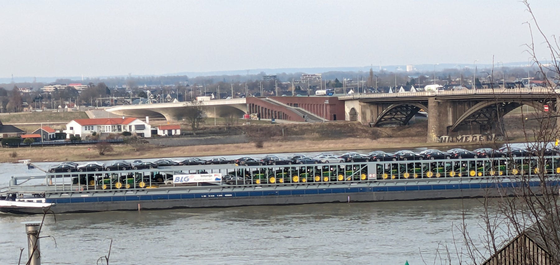 A barge carrying cars and John Deere tractors