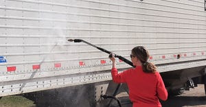 woman pressure spraying a semitrailer