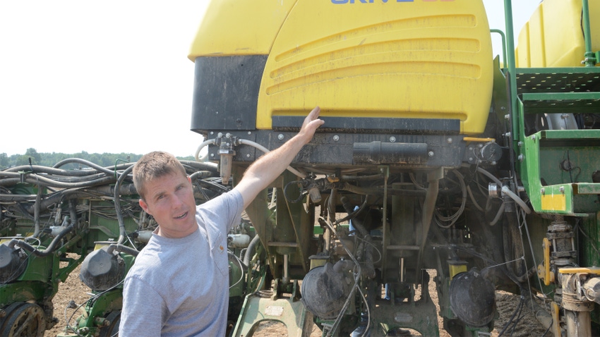 farmer points to 3RIVE 3D application tank mounted on the main bar of his corn planter
