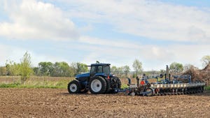 Blue tractor and planter planting corn