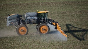 Self-propelled sprayer applying agriculture chemicals to a crop.