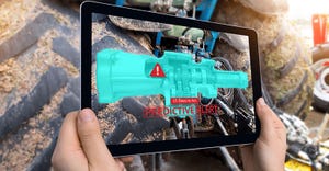 Hand holding tablet with AR maintenance application and predictive alert for part of machine.