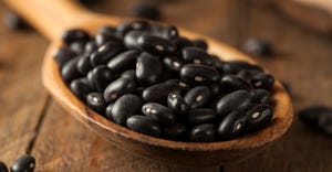spoonful of black beans in wooden spoon