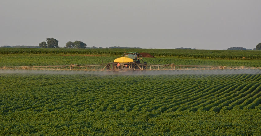 sprayer driving through field spraying beans sprayer driving through field spraying beans