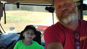 Roger Wenning with his grandson Travis taking a ride in the tractor