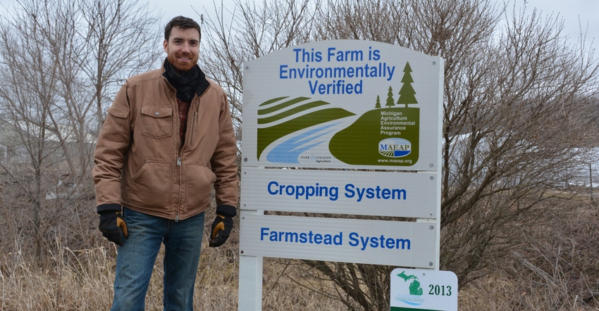 Matthew Romans stanfing by a sign that says this farm is enviromntally verified Matthew Romans stanfing by a sign that says this farm is enviromntally verified